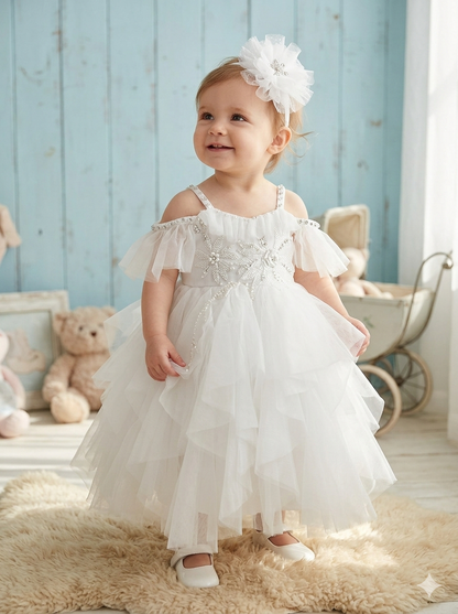 Child in a white chirstening dress with floral headband 