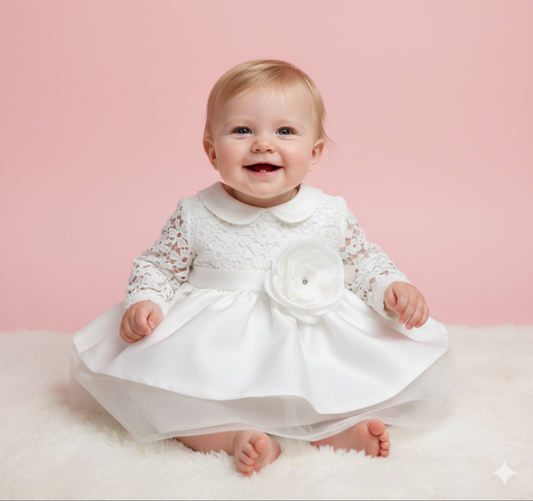 Baby girl in a white christening dress with a flower bow sitting on a pink background