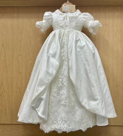 Elegant White lace christening dress on a wooden background