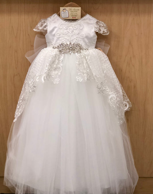 White lace dress with silver embellishments on a wooden background