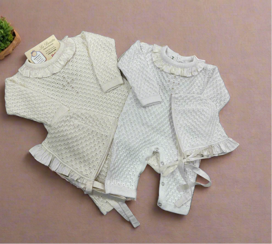 Two beige and white baby girl Christening outfits laid flat, one with a knit pattern and the other a solid color, both with silk ruffles around the neck.