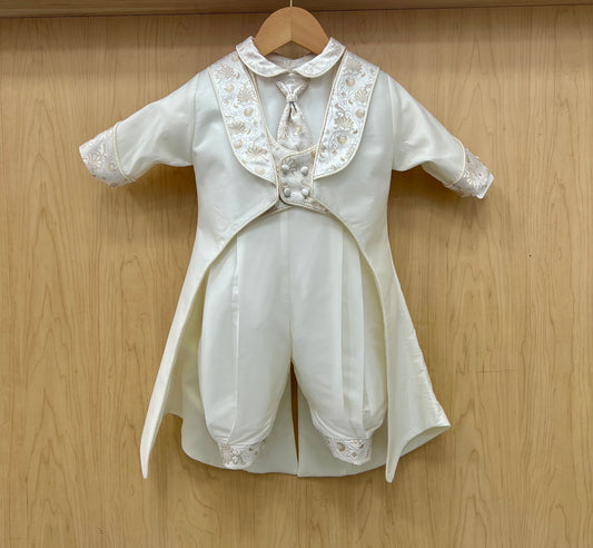 White baby chisteining outfit with lace details on a wooden background
