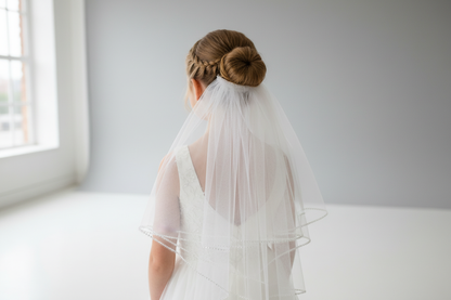 Back view of girl wearing communion veil with rhinestone edge